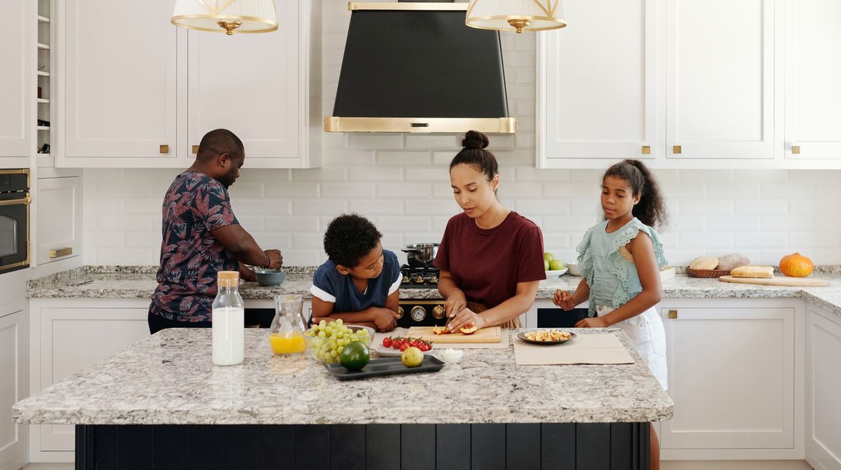 Familie bereitet gemeinsam Essen in der Küche zu